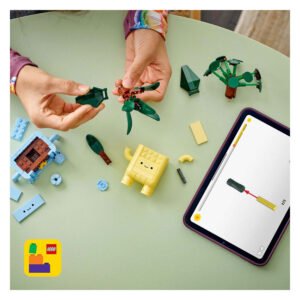 Kind bouwt LEGO Botanicals Happy Plants met tabletinstructies op tafel