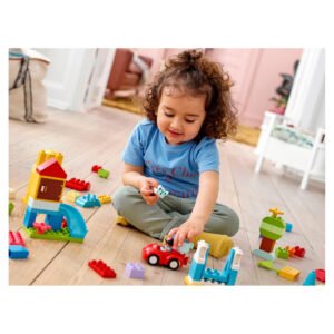 Peuter speelt op houten vloer met LEGO DUPLO autootje en blokken
