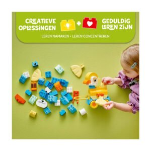 Kind ontdekt LEGO DUPLO stenen en eend terwijl ze speelt op groene ondergrond
