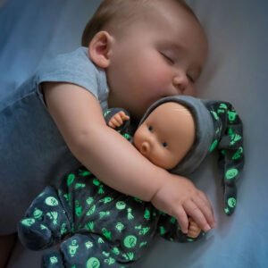 Baby slaapt met corolle glow-in-the-dark pop knuffelend in bed