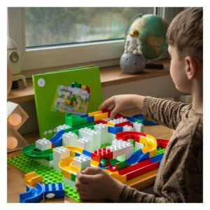 Kind bouwt eigen knikkerbaan met Hubelino onderdelen aan tafel