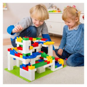 Kinderen spelen samen met de Hubelino kogelbaan set op de grond