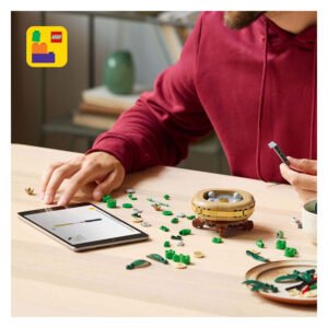 Persoon bouwt LEGO bamboeplant met instructies op tablet