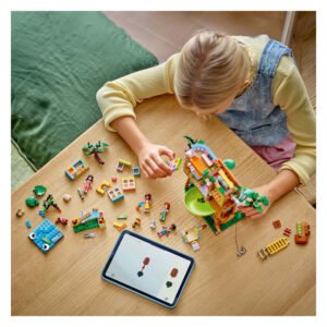 Kind bouwt LEGO Friends boomhut met tablet instructies