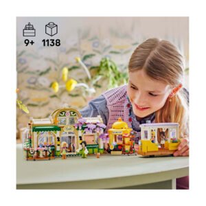 Meisje speelt met LEGO Friends café en tram set op tafel