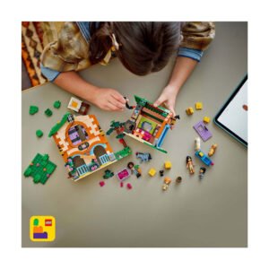 Kind speelt met LEGO Friends paardenspeelset op tafel met tablet erbij