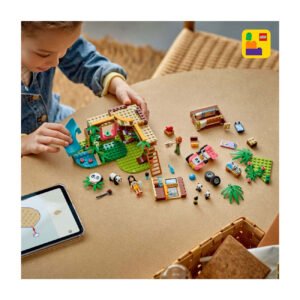Kind bouwt LEGO Friends panda-boomhut met kleurrijke onderdelen en tablet-instructies