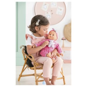 Klein meisje knuffelt corolle babypop met roze kleding en strik