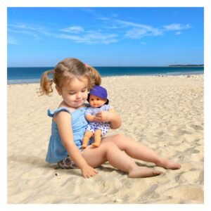 Peuter speelt met Corolle badpop Marin op het strand