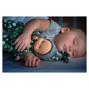 Slapende baby houdt corolle glow-in-the-dark pop dicht tegen zich aan