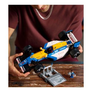 Man houdt LEGO Williams raceauto boven display met naamplaatje