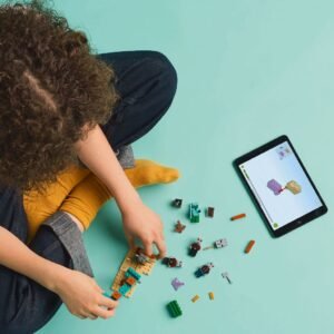 Kind bouwt LEGO Minecraft set met hulp van tablet-instructies