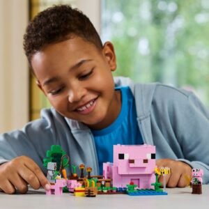 Kind speelt met LEGO Minecraft Baby Pig House bouwset aan tafel