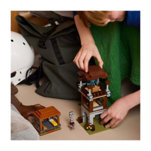 Kinderen bouwen LEGO Minecraft uitkijktoren en stal op de vloer