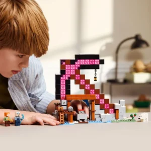 Jongen speelt met LEGO Minecraft set met grote roze houweel en TNT-blokken