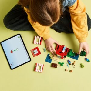 Kind bouwt LEGO Minecraft TNT Jungle House met tablet als digitale handleiding