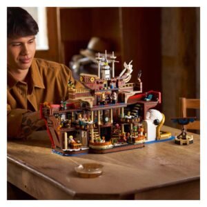 Man bewondert gedetailleerde LEGO Baratie restaurant set op tafel