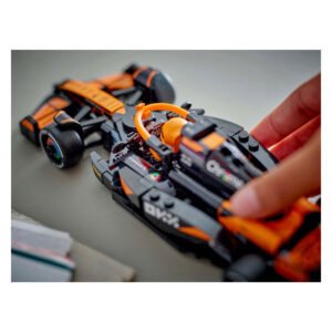 Hand bestuurt LEGO Formule 1 McLaren raceauto tijdens het spelen