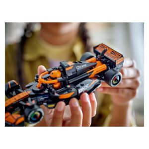 Kind houdt LEGO McLaren F1 raceauto vast tijdens het spelen
