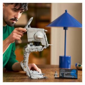 Man bouwt LEGO Star Wars AT-ST model op houten tafel