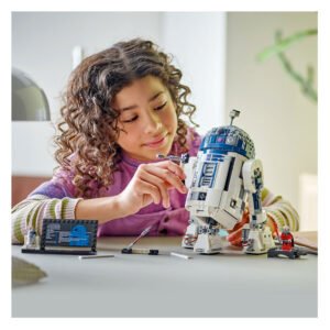 Kind speelt met LEGO Star Wars R2-D2 bouwset op bureau of speeltafel