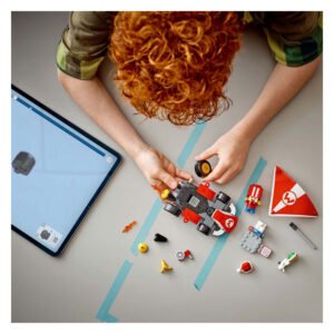 Kind bouwt LEGO Super Mario kart met tablet instructies op tafel