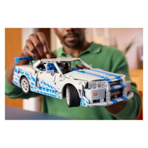 Gedetailleerde close-up van LEGO Technic Nissan Skyline GT-R in handen van een man