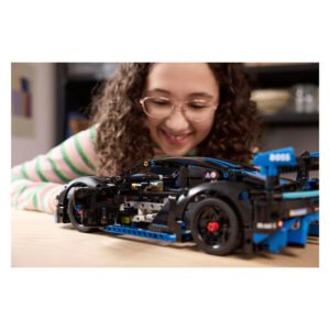 Kind bewondert LEGO Technic Porsche GT4 racewagen op tafel