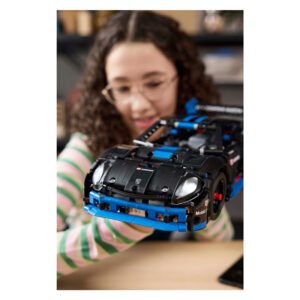 Meisje toont trots LEGO Technic Porsche GT4 model van dichtbij