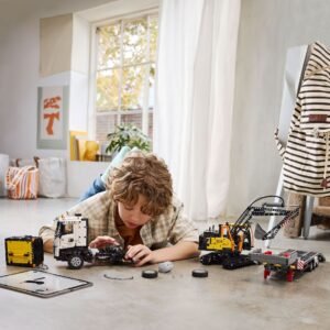 Jongen bouwt LEGO Volvo truck en EC230 graafmachine in lichte kamer