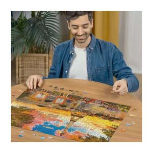 Man legt Ravensburger puzzel met Eiffeltoren op houten tafel