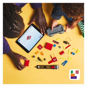 Kinderen bouwen LEGO brandweerwagen met behulp van tablet en bouwstenen