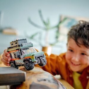 Kind speelt met LEGO terreinwagen over houten oppervlak