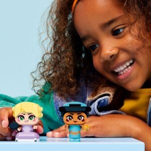 Lachend kind speelt met LEGO Disney figuren Rapunzel en Jasmine