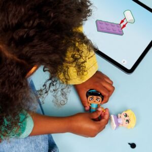 Kind speelt met LEGO Disney Jasmine en Rapunzel figuren naast een tablet