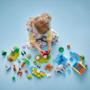 Kleuter speelt met losse LEGO DUPLO dieren en bouwstenen op de vloer