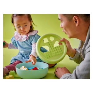 Peuter speelt met sorteerspeelgoed en LEGO DUPLO stenen samen met vader