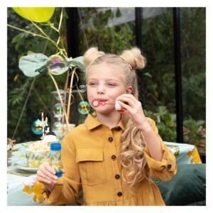 meisje blaast bellen op kinderfeestje met dinosaurus thema