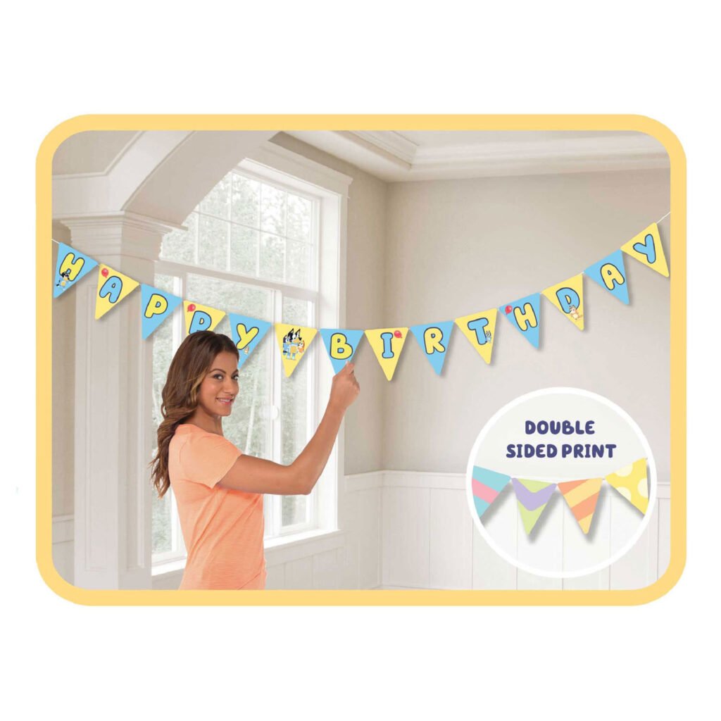 Vrouw hangt kleurrijke Happy Birthday vlaggenlijn met dubbele print op in lichte woonkamer vlaggenlijn papier bluey