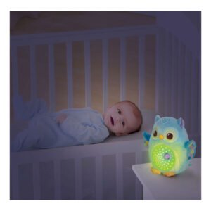 Baby ligt in ledikant naast lichtgevend uiltje muzieknachtlamp