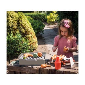 kind speelt met speelgoed barbecue set in tuin