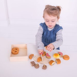 Peuter speelt met houten speelgoed ontbijtset en snijfruit