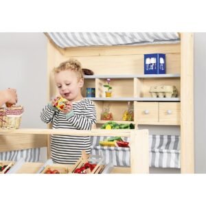Kind speelt met houten marktkraam voor kinderen met speelgoedgroente