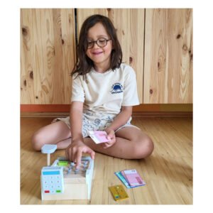 Kind speelt met houten speelgoed kassa en speelgeld