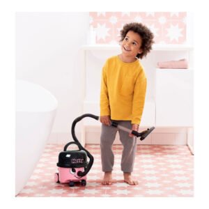 Kind speelt met roze Hetty speelgoedstofzuiger in badkamer