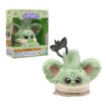 Furby Furblets Grogu Interactieve knuffel met de verpakking, met grote ogen, groene vacht en keychain-accessoire zichtbaar.