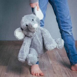 Zachte grijze knuffelolifant gedragen door een kind