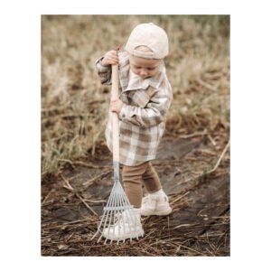 Peuter met houten kinderhark tijdens tuinieren
