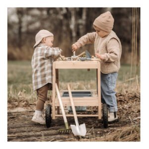 Kinderen spelen met houten modderkeuken en tuingereedschap