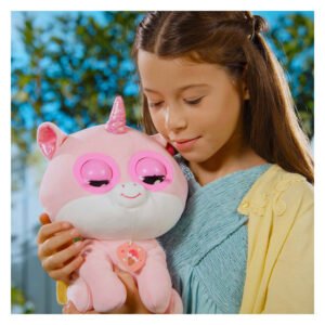 Jong meisje kijkt liefdevol naar een interactieve roze eenhoorn knuffel buiten